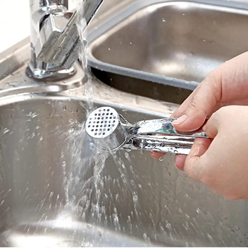 Espremedor de alho manual em aço inox com alça ergonômica em fundo branco