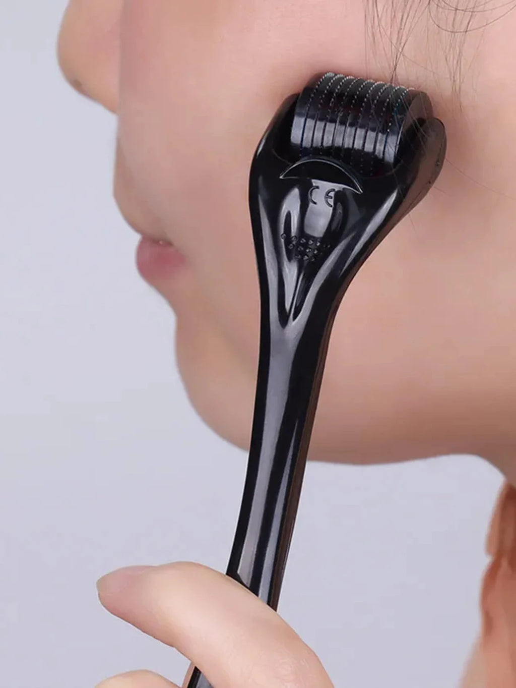 Dermaroller 540 agulhas de titânio para microagulhamento facial em fundo branco