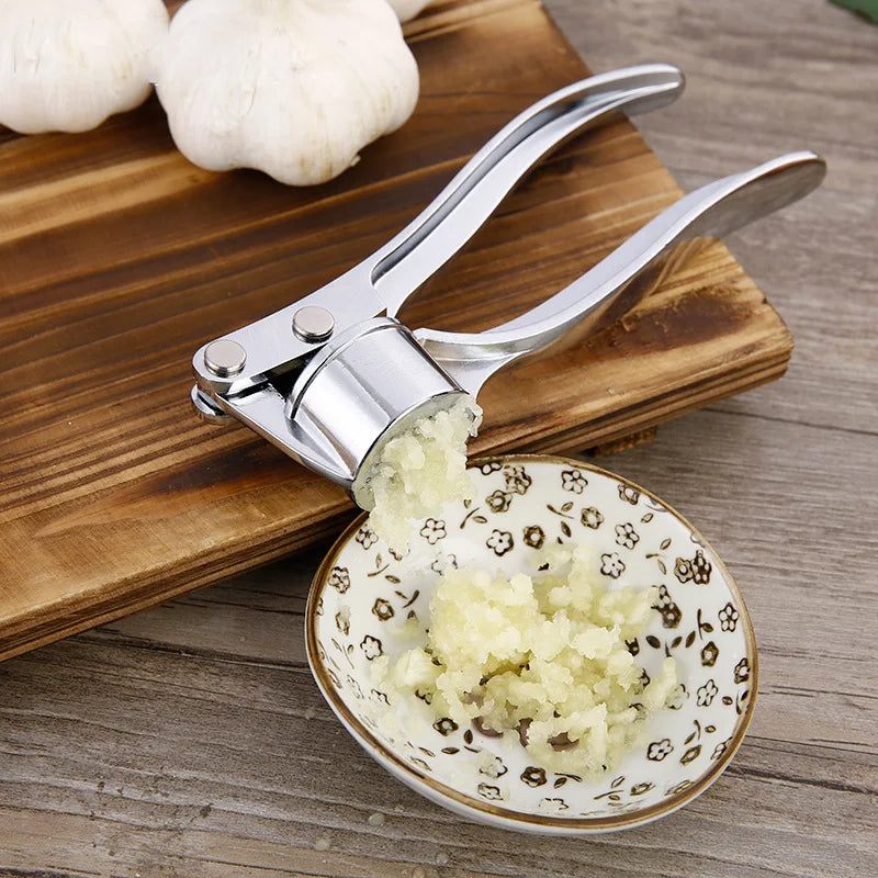 Espremedor de alho manual em aço inox com alça ergonômica em fundo branco